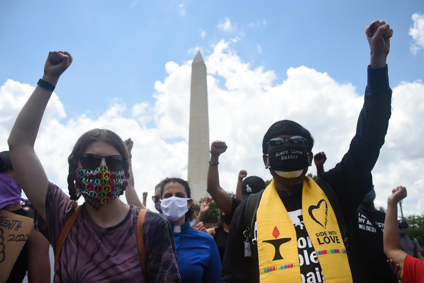 Demonstrators raise their fists during a Juneteenth march and rally by the Washington Monument.