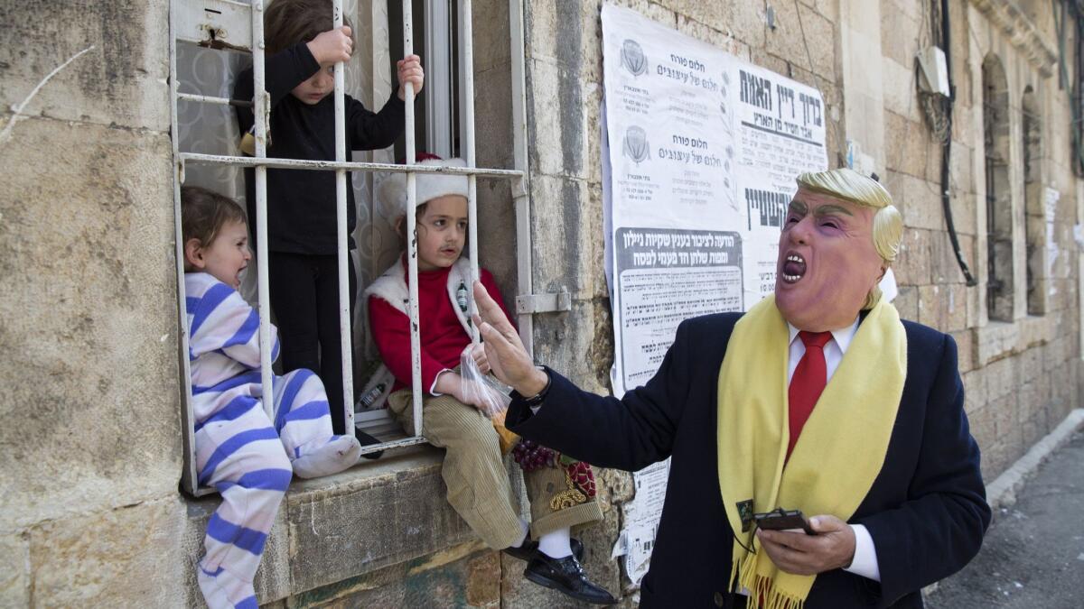 A man wears a mask of President Trump during the Purim festival in the ultra-Orthodox Mea Shearim neighborhood in Jerusalem on March 22, 2019.
