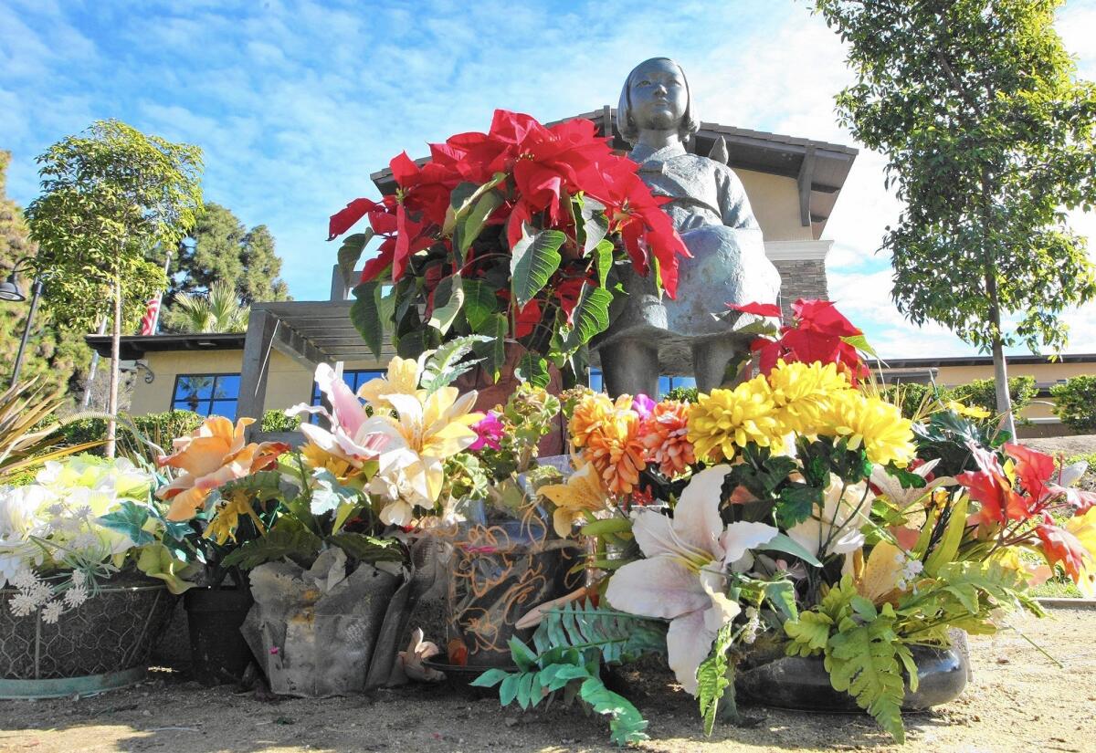 Flowers were left in front of the comfort-women statue in Glendale on Monday, Dec. 28, 2015.
