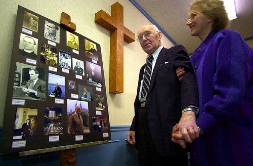 The effort to get the words "under God" added to the Pledge of Allegiance grew from a 1952 sermon by the Rev. George M. Docherty, shown looking at photos of his career with his wife, Sue.