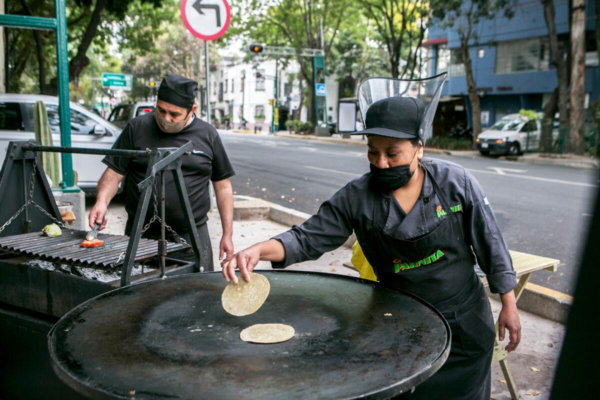 Employees at Mexico City restaurant El Parnita cook outdoors