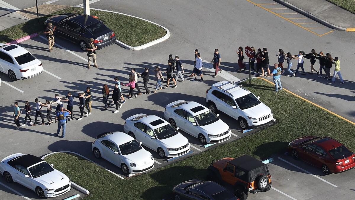 Students are brought out of Marjory Stoneman Douglas High School after the shooting.