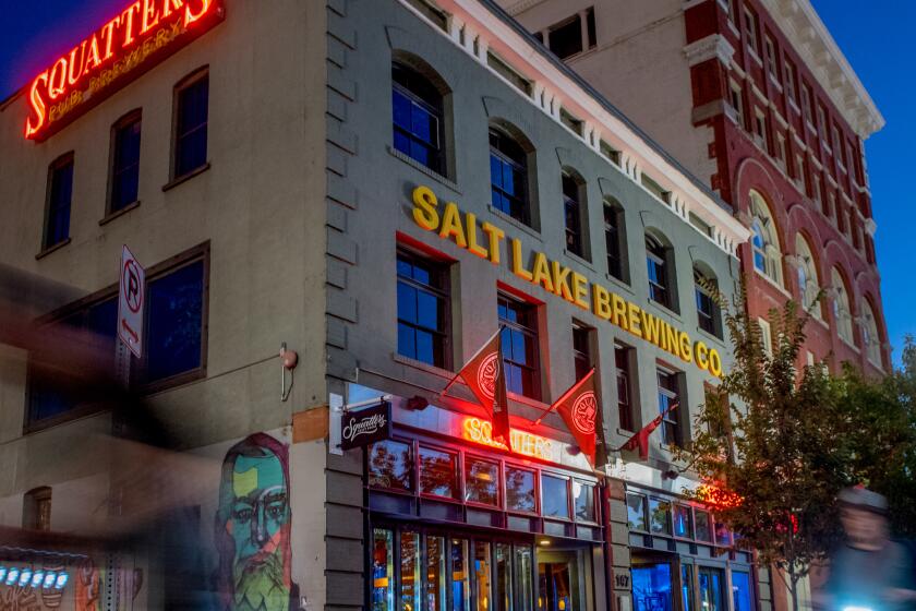 People pass by Squatters Pub on scooters Saturday, July 27, 2019, in downtown Salt Lake City, Utah. Isaac Hale / For The Times