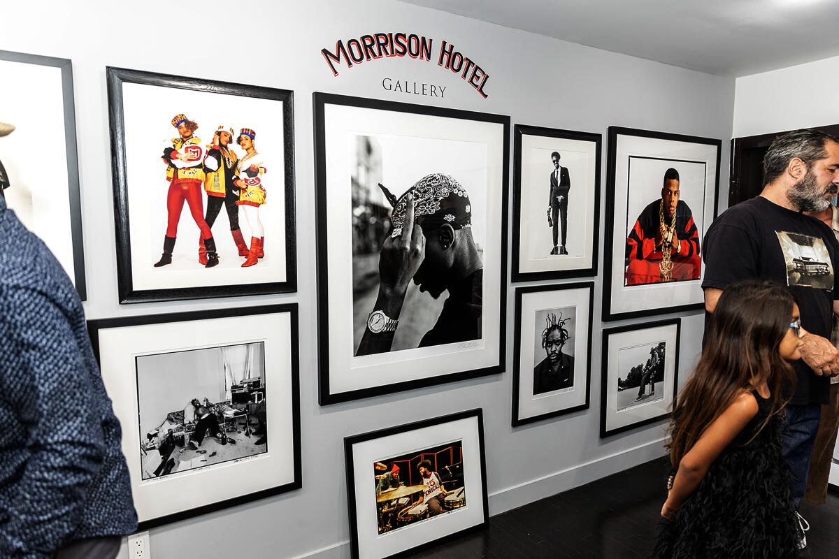 Photos of Tupac, Salt-N-Pepa and other hip-hop artists hang in black picture frames on the wall.