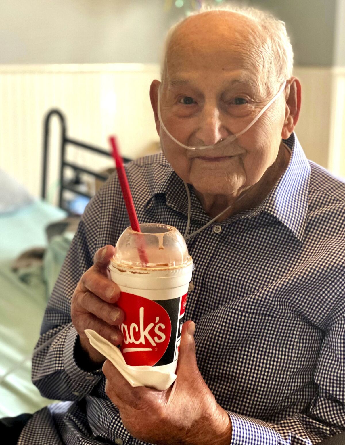 World War II veteran and COVID-19 survivor Major Wooten holds a celebratory milkshake on his 104th birthday Thursday.