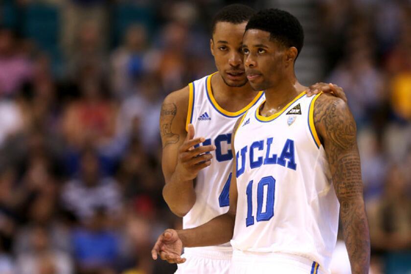 Bruins guards Norman Powell and Larry Drew II (10) talk strategy during the Pac-12 Conference tournament championship game.
