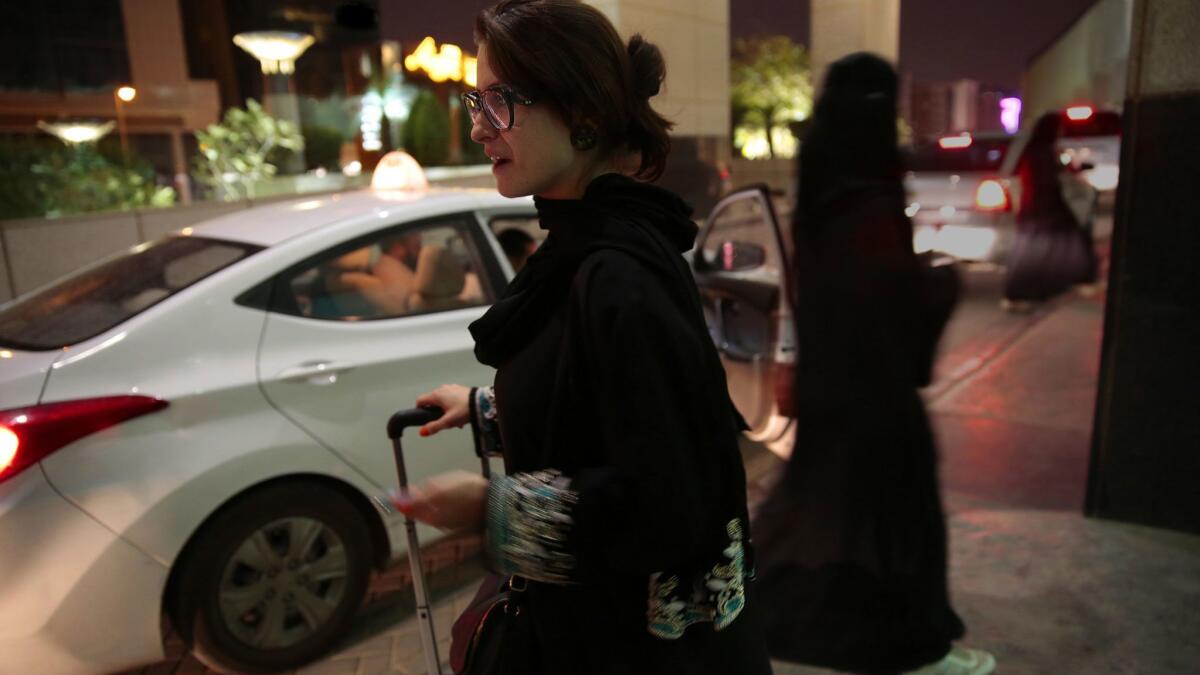 A woman waits for an Uber ride at Kingdom Center shopping mall in Riyadh, Saudi Arabia.