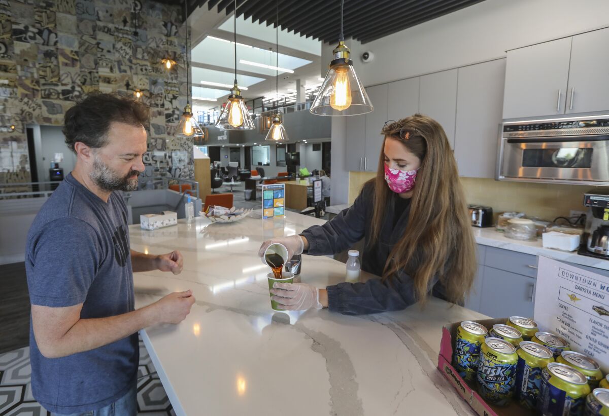 Jennifer Johnson serves a coffee to Lance Carter at Downtown Works in San Diego.