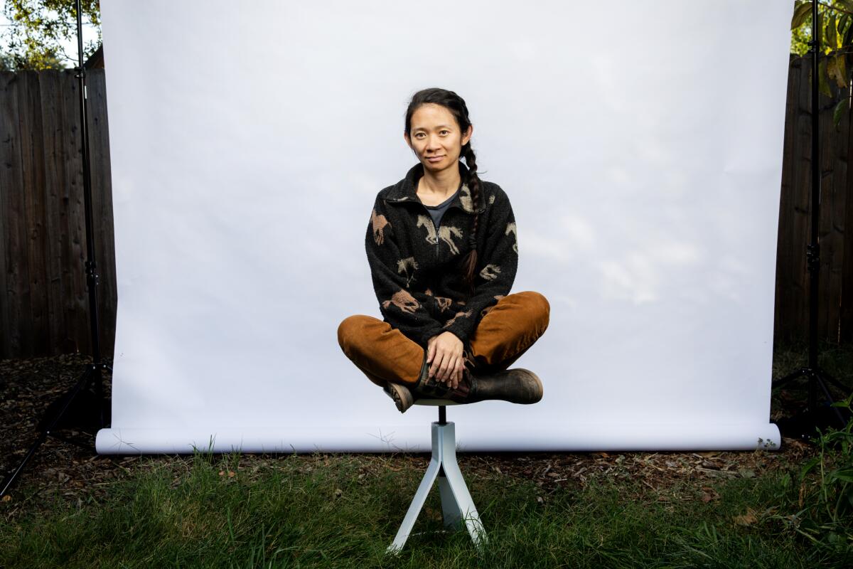 "Nomadland" director Chloé Zhao sitting in the backyard of her home.