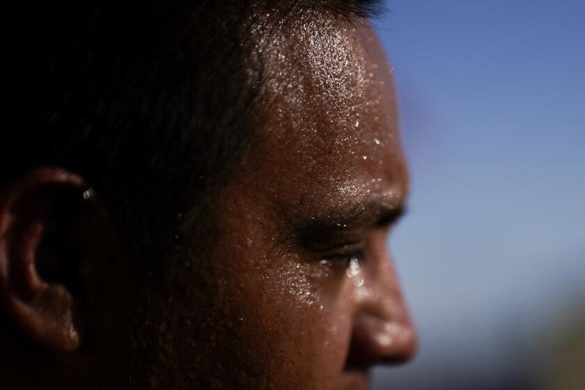 Sweat covers the face of Juan Carlos Biseno after dancing to music from his headphones as afternoon temperatures reach 115 degrees Fahrenheit (46.1 Celsius) Wednesday, July 19, 2023, in Calexico, Calif. Residents along the United States' border with Mexico endured more blistering heat on Wednesday, as forecasters predicted more high temperatures to come. (AP Photo/Gregory Bull)