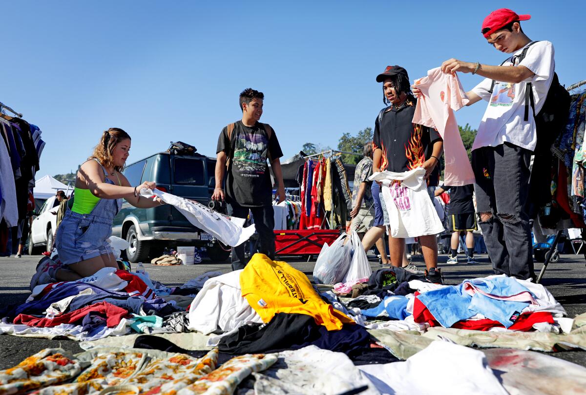 From left, Maria Davila, Ramon Lavares, Miles Miller and Matt Vallin, all from the San Fernando Valley, sift through the"$2 pile" at the flea market.