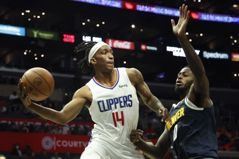 Los Angeles Clippers guard Terance Mann (14) looks to pass the ball against Denver Nuggets forward JaMychal Green (0) during the second half of a preseason NBA basketball game, Monday, Oct. 4, 2021, in Los Angeles. The Clippers won 103-102. (AP Photo/Ringo H.W. Chiu)
