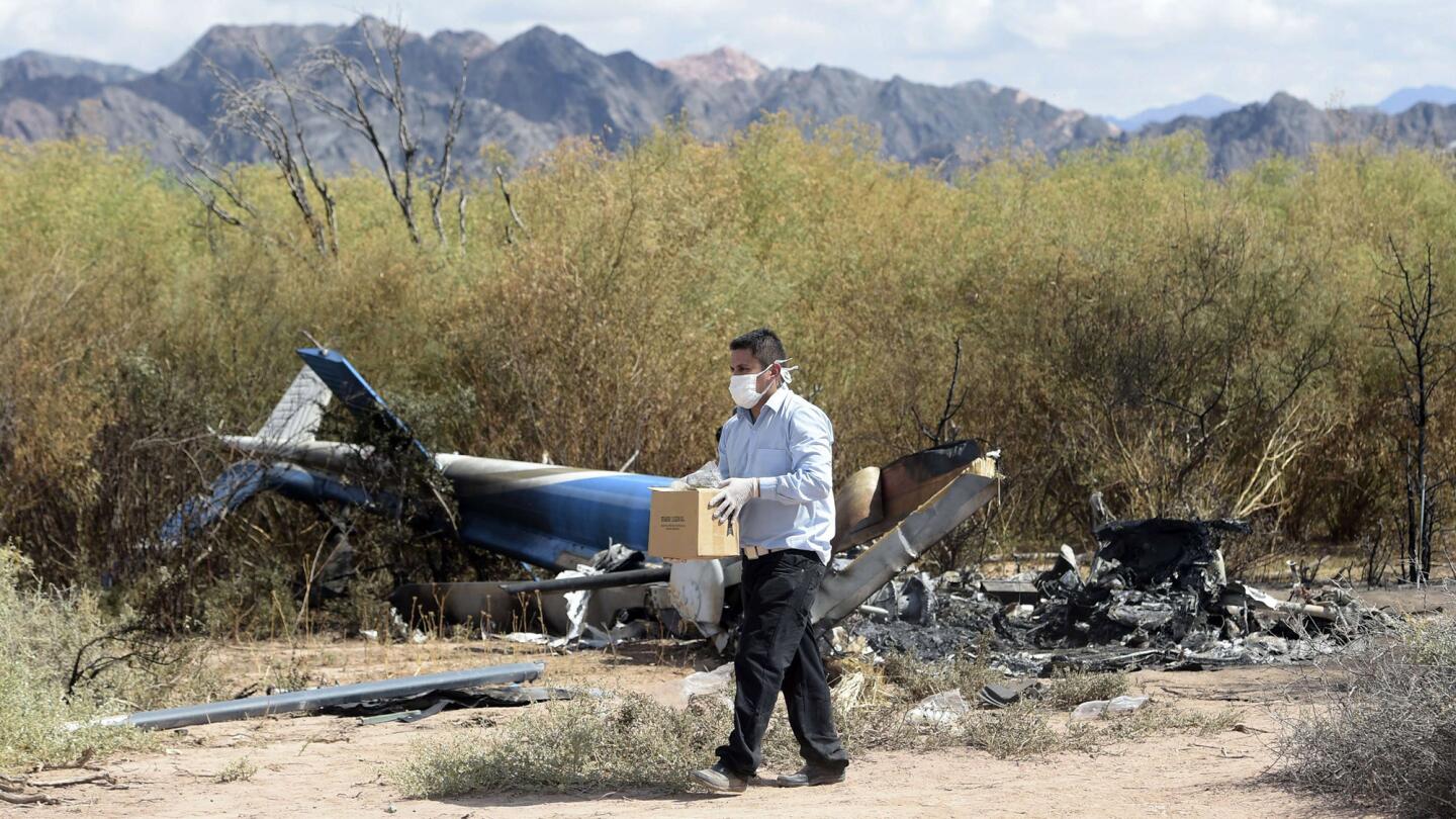 An investigator works amid the wreckage of two helicopters that collided mid-air near Villa Castelli, in the Argentine province of La Rioja. Ten people were killed, including a group of French sports stars participating in a reality TV show.