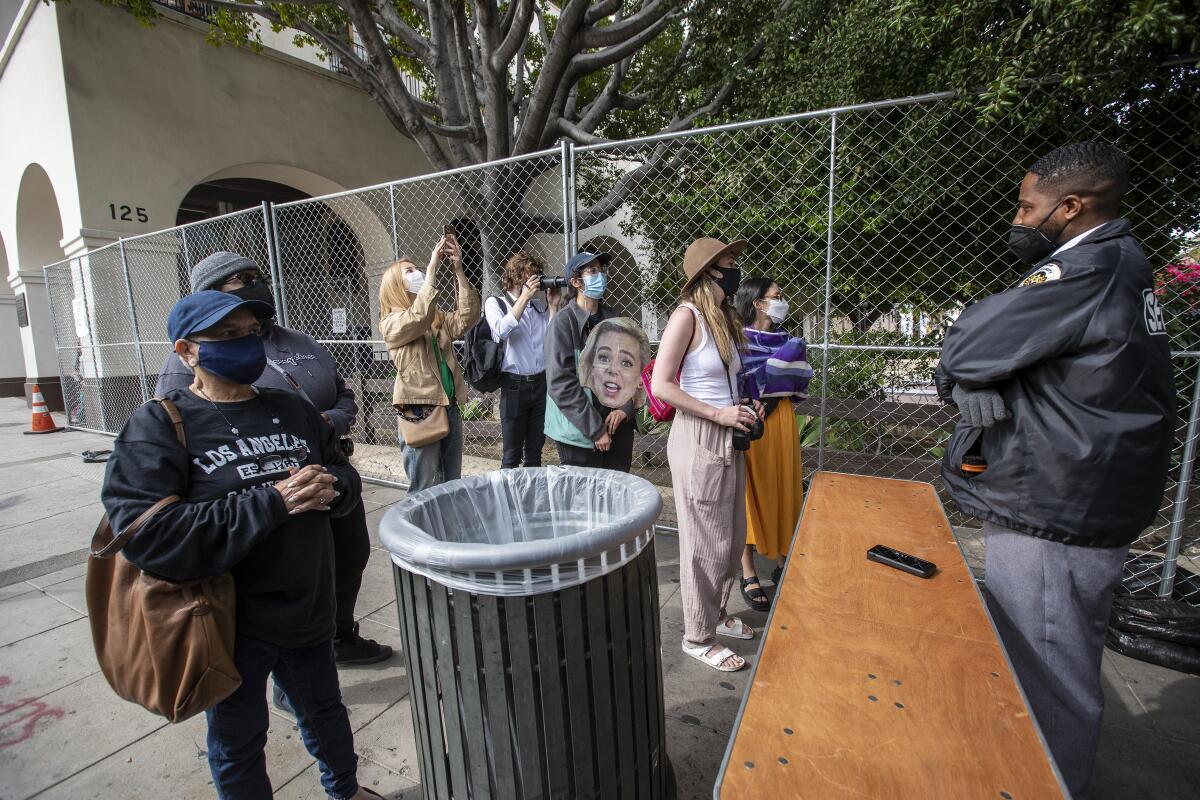  A small group on Olvera Street raises phones and watches expectantly.