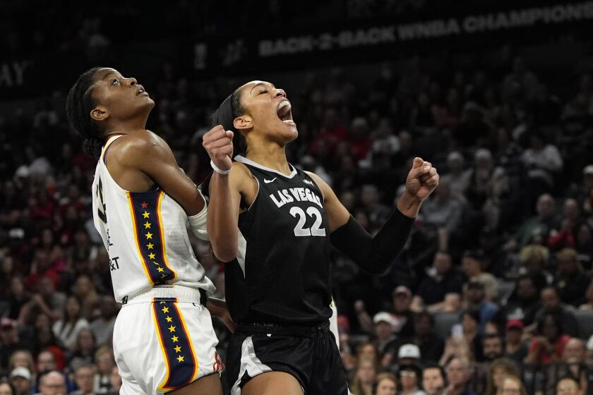 Las Vegas Aces center A'ja Wilson (22) reacts after a play agaist Indiana Fever center Temi Fagbenle (14) during the first half of a WNBA basketball game Saturday, May 25, 2024, in Las Vegas. (AP Photo/John Locher)