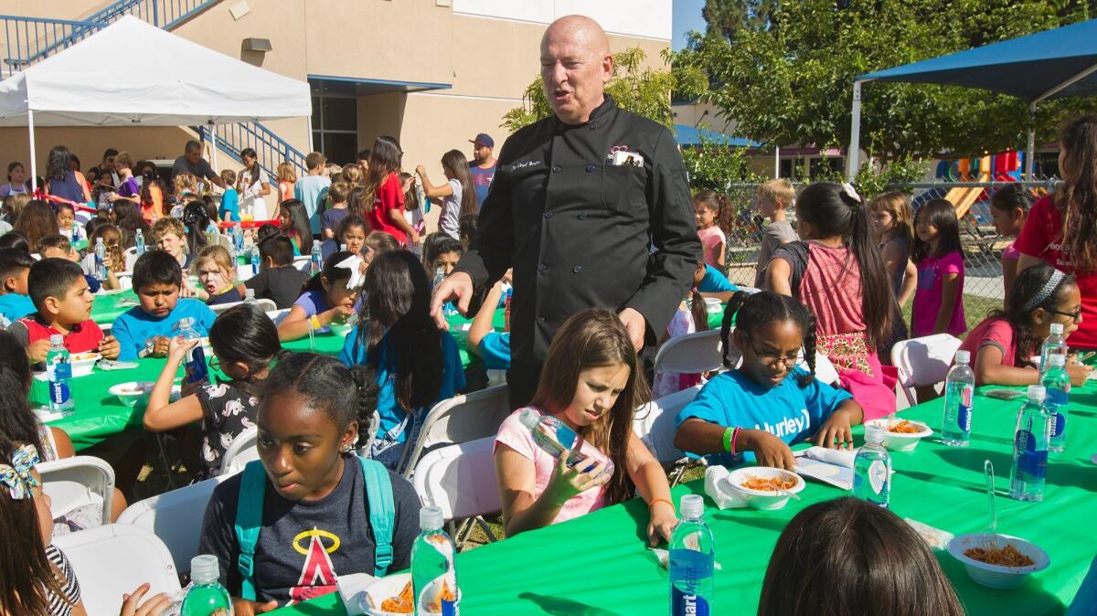 Chef Bruno Serato greets children as they enjoy his pasta at the Boys & Girls Club of Huntington Valley — Pacific Life Foundation Branch in Huntington Beach on Tuesday.
