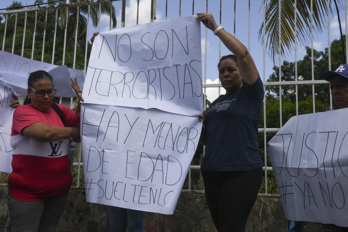 Familiares de los detenidos sostienen carteles afuera de la cárcel de Tocuyito 