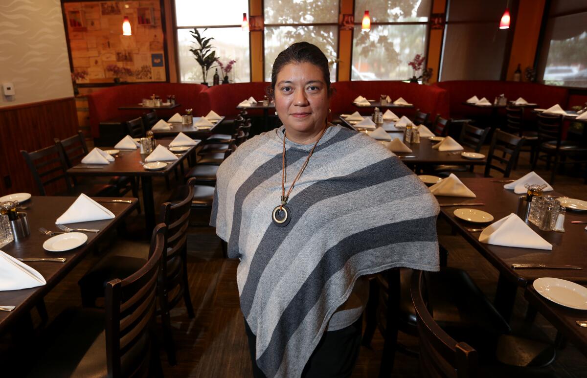 Teresa Razo stands in the dining room of Villa Roma restaurant and market in Laguna Hills.