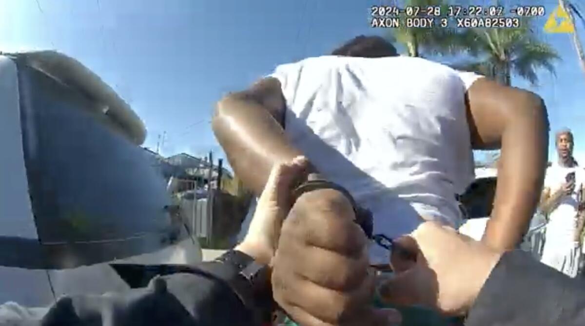 An image from body cam video of a person being handcuffed from police officer's point of view