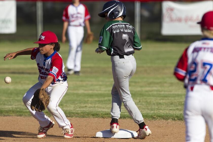 Costa Mesa American Little League's Kyle Cowley is safe at second as Costa Mesa National Little League's Dimitri Susidko attempts to field the throw during game two of the Mayor's Cup series on Monday.