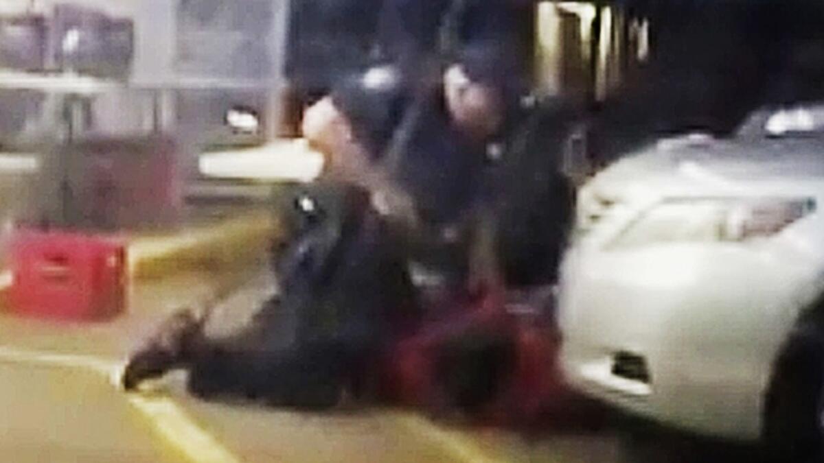 In this July 5, 2016, image made from video, Alton Sterling is restrained by two police officers, one holding a gun, outside a convenience store in Baton Rouge, La. Moments later, Officer Blane Salamoni shot and killed Sterling.