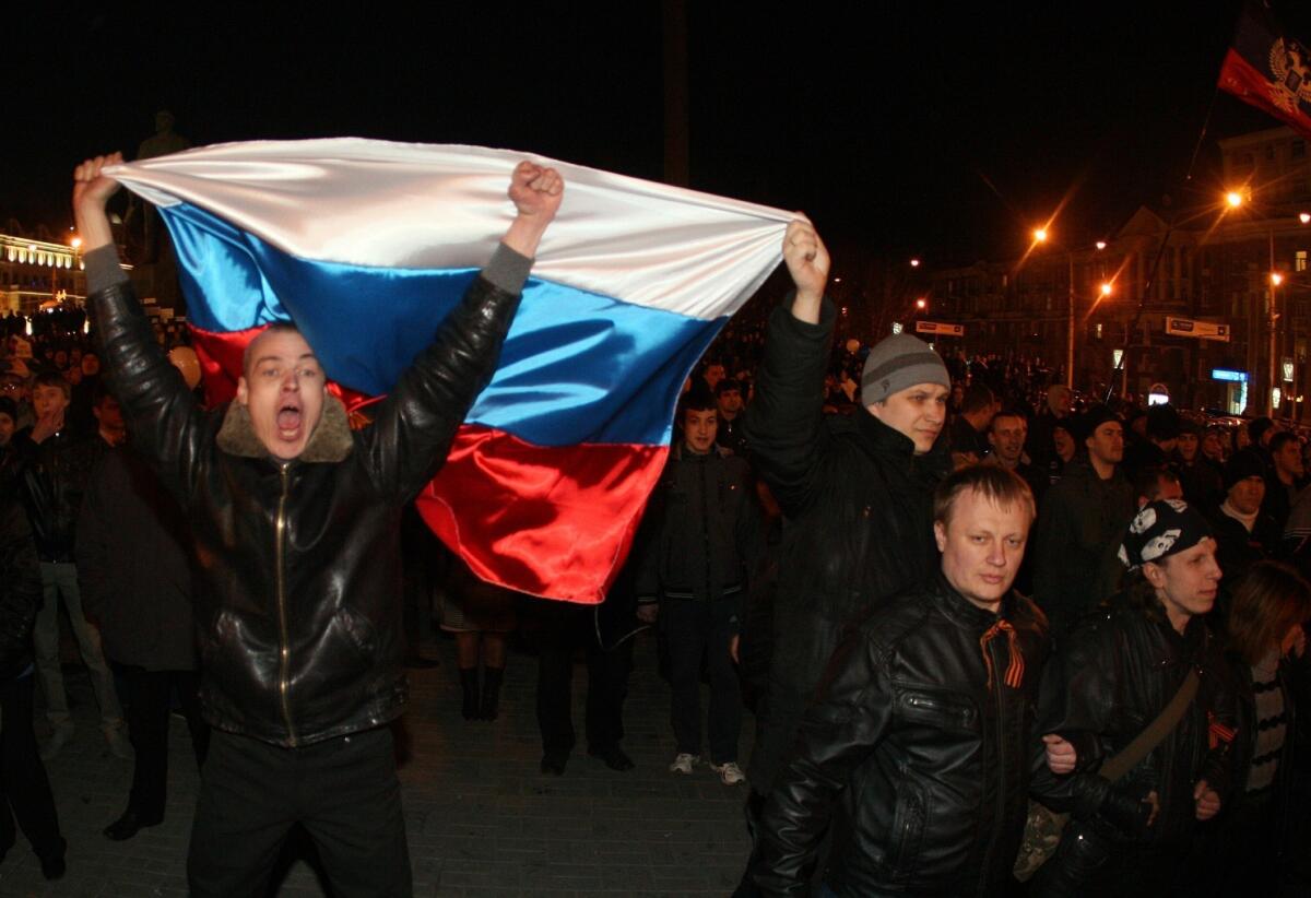 Pro-Russian activists hold Russian flags during a rally in the eastern Ukrainian city of Donetsk on Thursday.