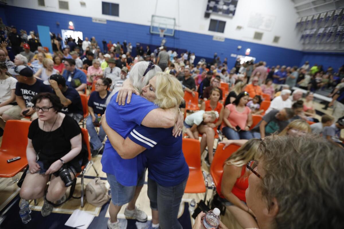 At Trona High School, Lauretta Eldridge, right, hugs Joyce Surles of Trona. Residents gathered to hear updates and voice their concerns at a town hall meeting. Eldridge, who grew up in the town, came in from Bakersfield to look after her parents.