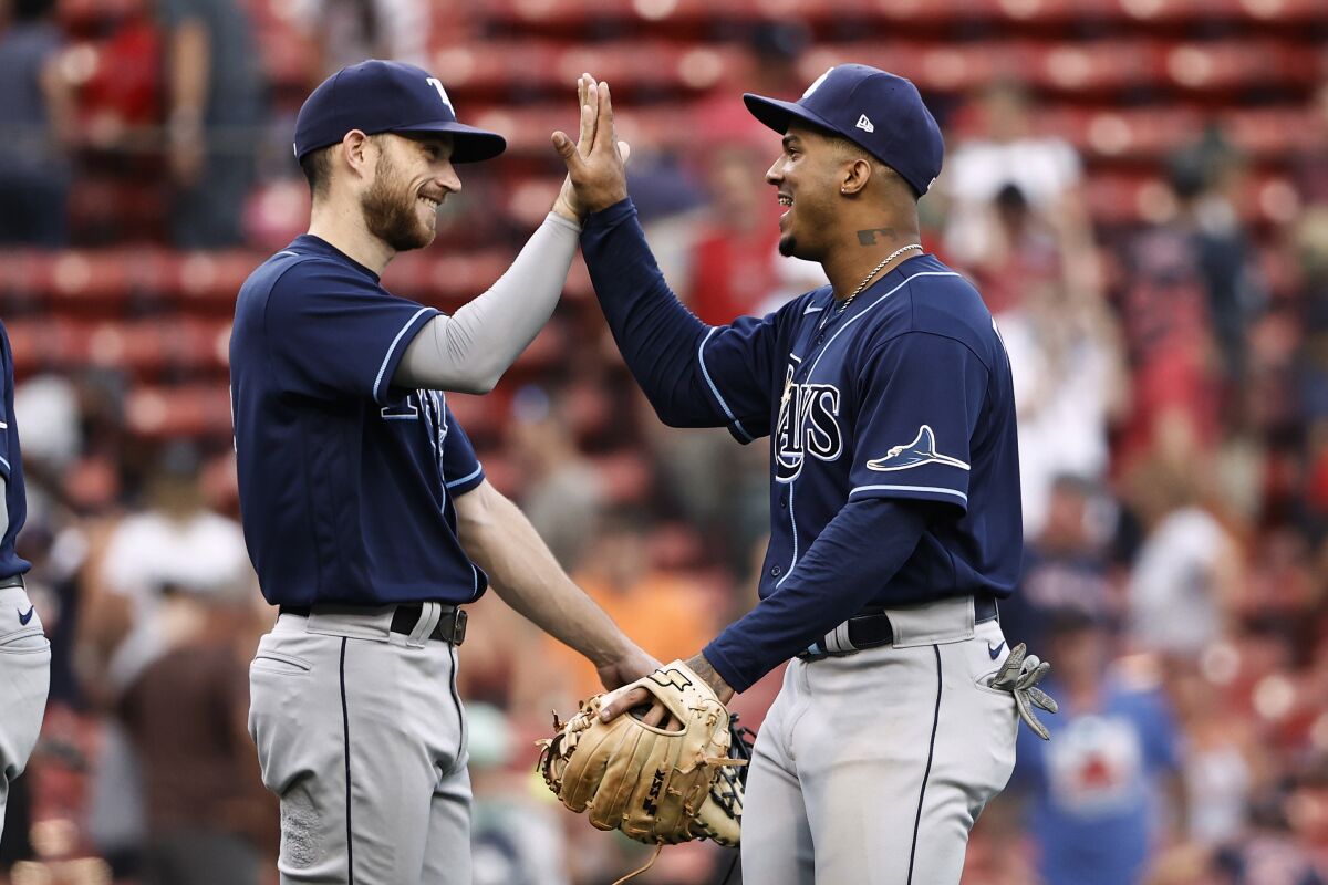 Tampa Bay Rays' Wander Franco, right, celebrates with relief pitcher Collin McHugh after they defeated the Boston Red Sox in 10 innings of a baseball game Monday, Sept. 6, 2021, at Fenway Park in Boston. (AP Photo/Winslow Townson)