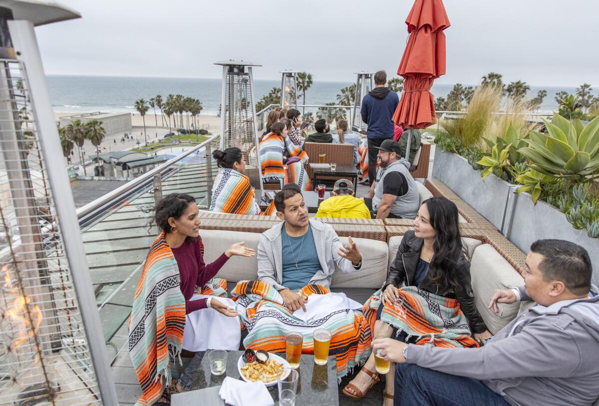 Mikki Hernandez from left, Lorenzo Cruz, Casey Wu and Colin Linggo hang out at Hotel Erwin rooftop lounge on a cloudy Venice evening on April 19, 2019.