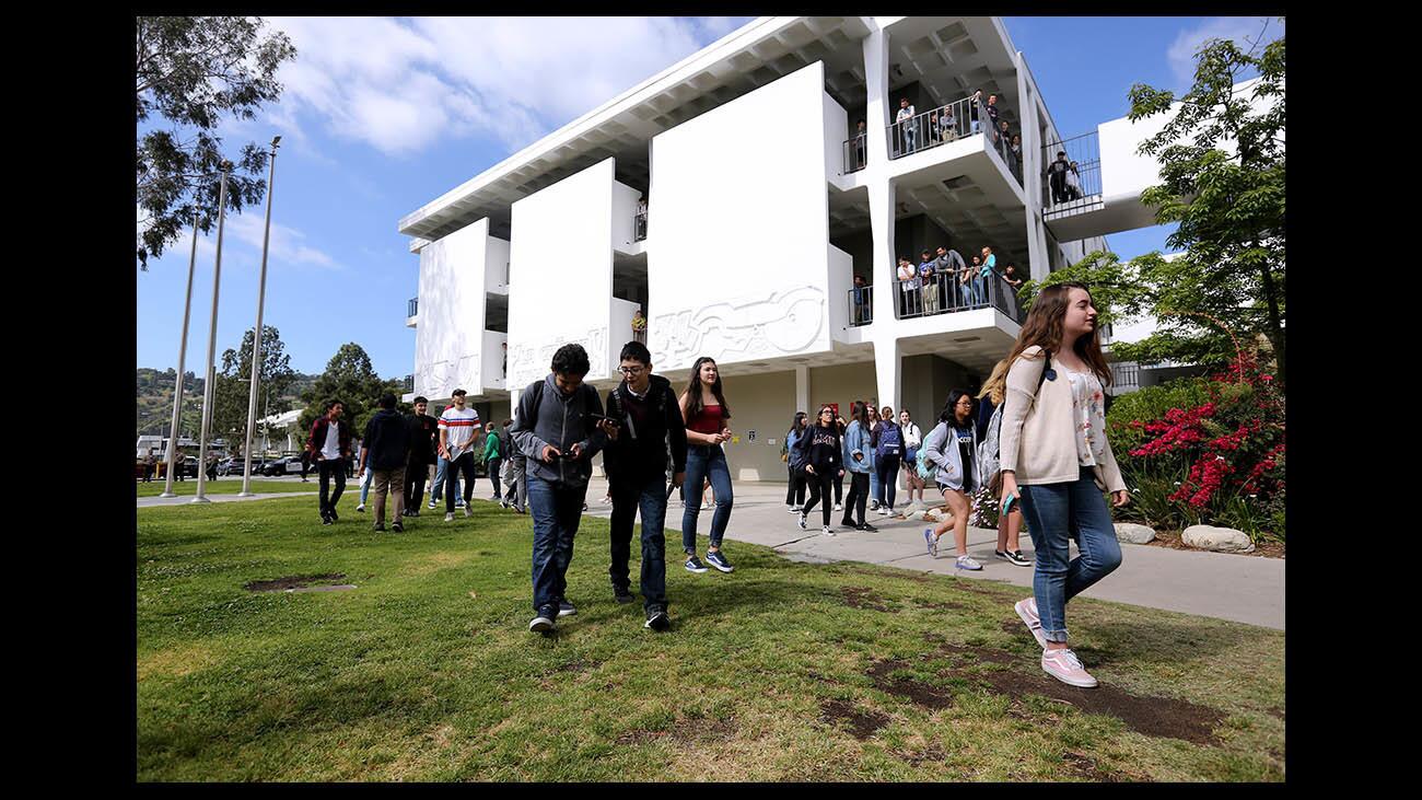 While other students watch from above, about 40 La Cañada High School students walked out of school to march 2 miles to the Memorial Park to protest gun violence on the anniversary of the Columbine massacre on Friday, April 20, 2018.