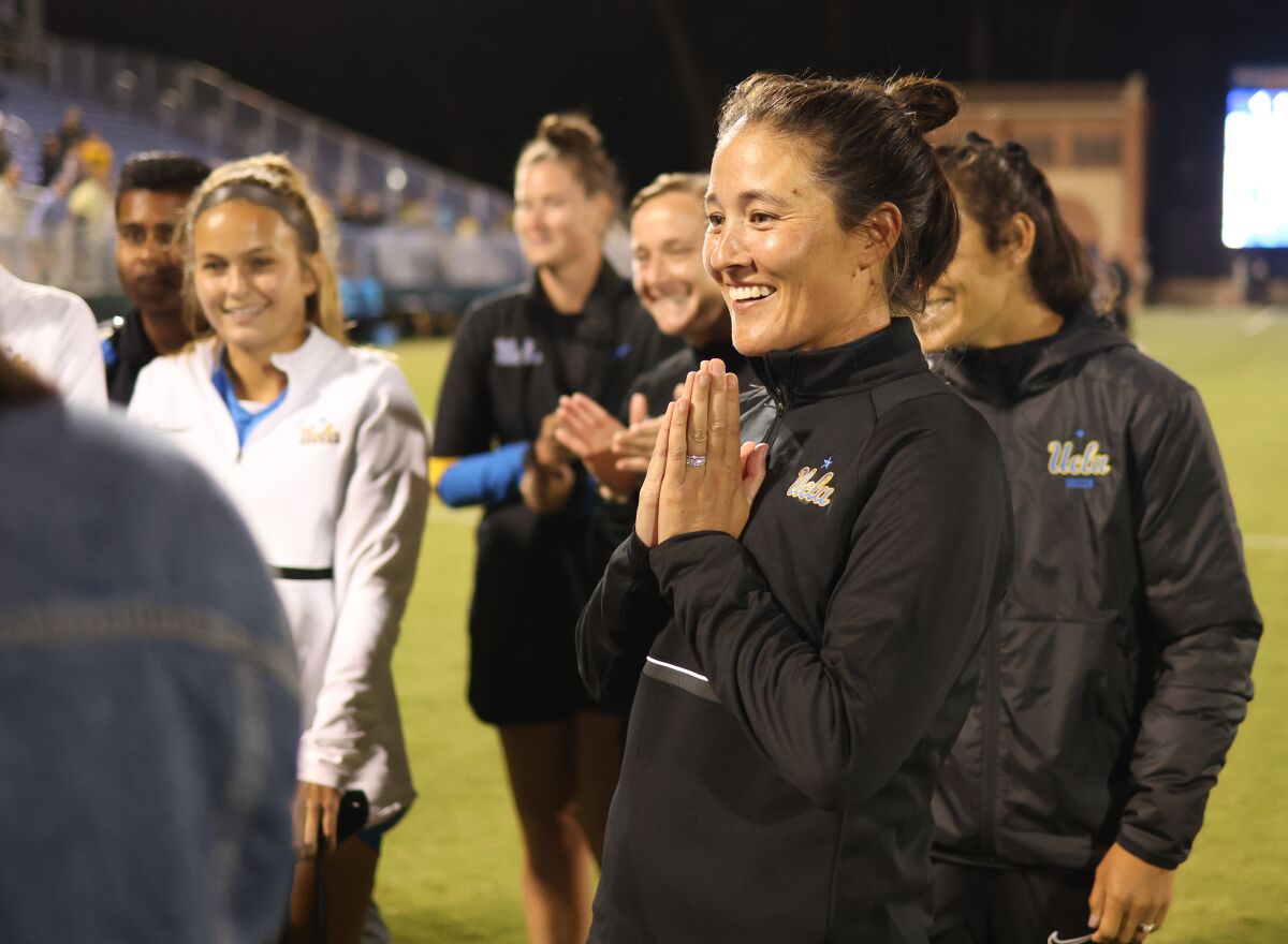 UCLA coach Margueritte Aozasa celebrates with her team following a season-opening win over Iowa 