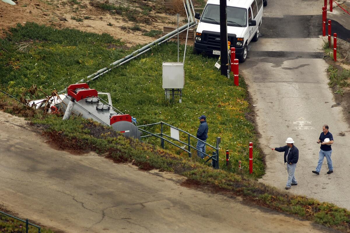 Los Angeles Police and Southern California Gas Co. officials inspect the area where a truck, left, caused a gas leak at a storage facility in Play del Rey on Feb. 17.