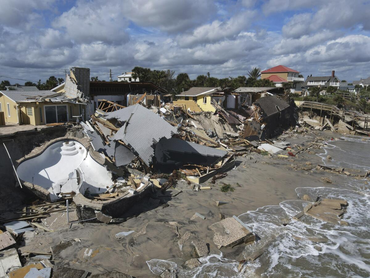 Homes are damaged and collapsed after the shore on which they stood was swept away, following the passage of Hurricane Nicole, Friday, Nov. 11, 2022, in Wilbur-By-The-Sea, Fla. (AP Photo/Rebecca Blackwell)