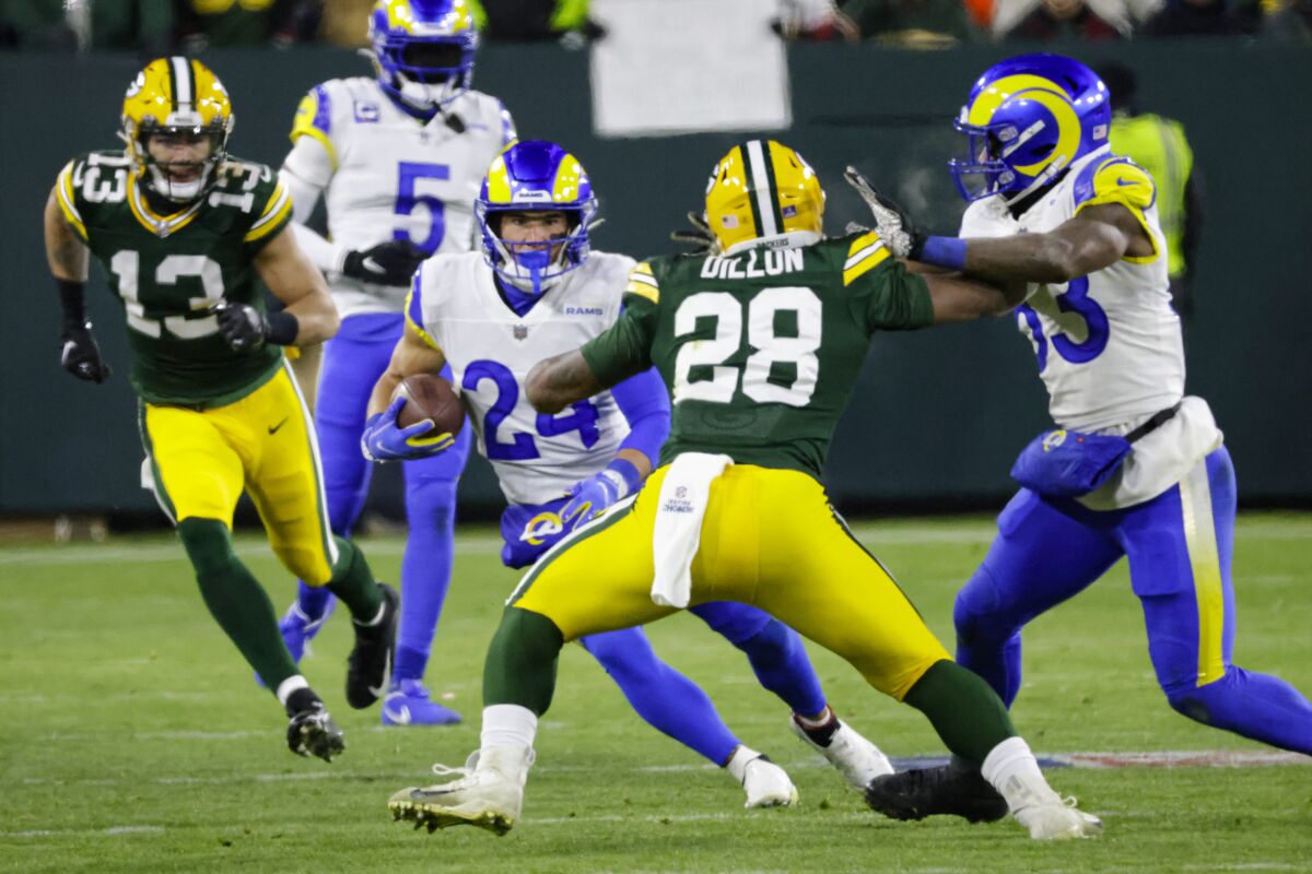 Taylor Rapp (24) cuts away from Packers running back AJ Dillon (28) after an interception in the first half.