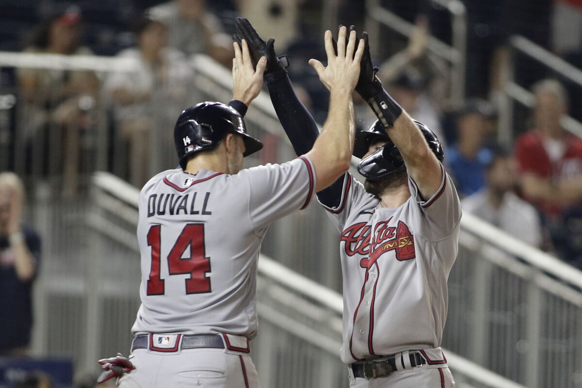 Atlanta Braves' Dansby Swanson, right, celebrates his two-run home run with teammate Adam Duvall (14) during the sixth inning of a baseball game against the Washington Nationals, Monday, June 13, 2022, in Washington. (AP Photo/Luis M. Alvarez)