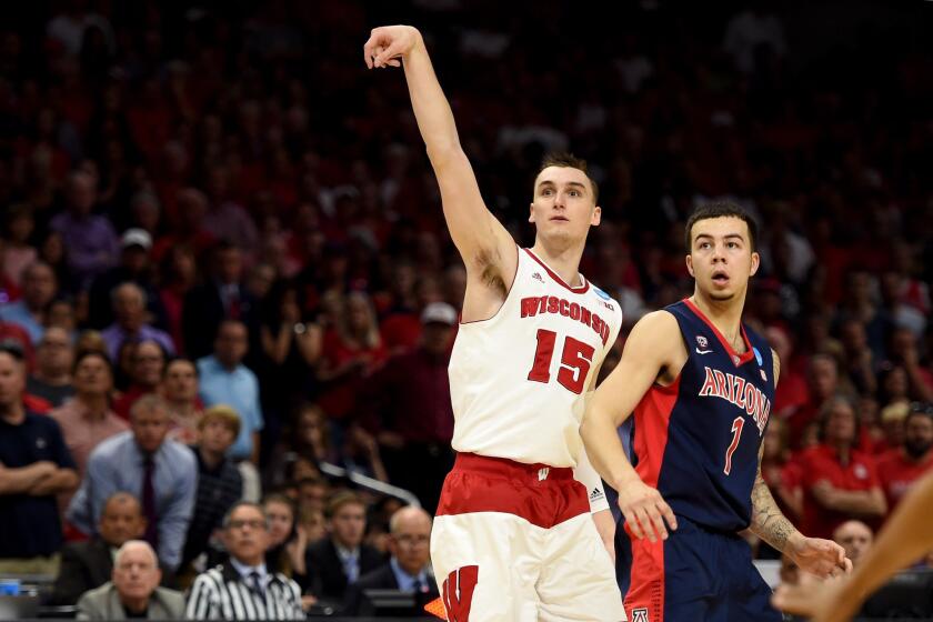 Wisconsin guard Sam Dekker (15) watches his shot against Gabe York (1) and Arizona in second half of the West Regional final.