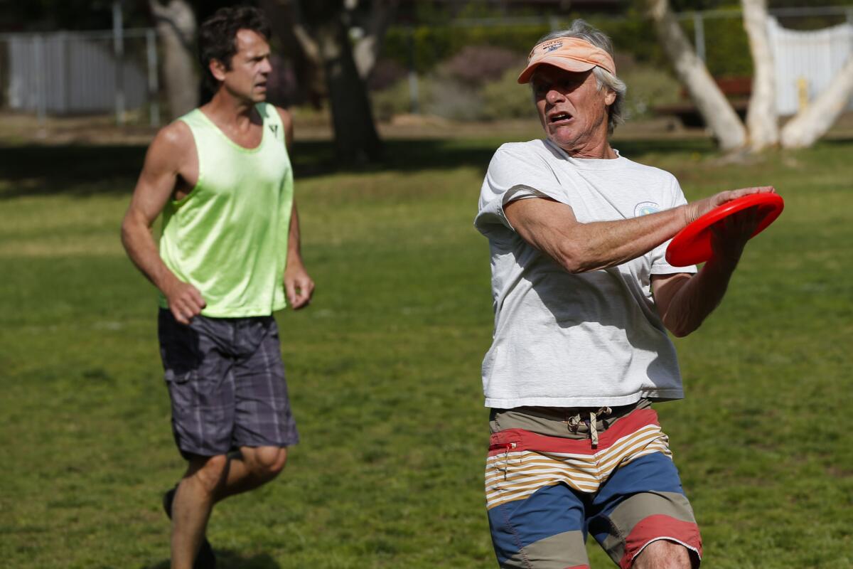 Michael McDonnell, right, grabs a frisbee as Mike Lansbury looks on.