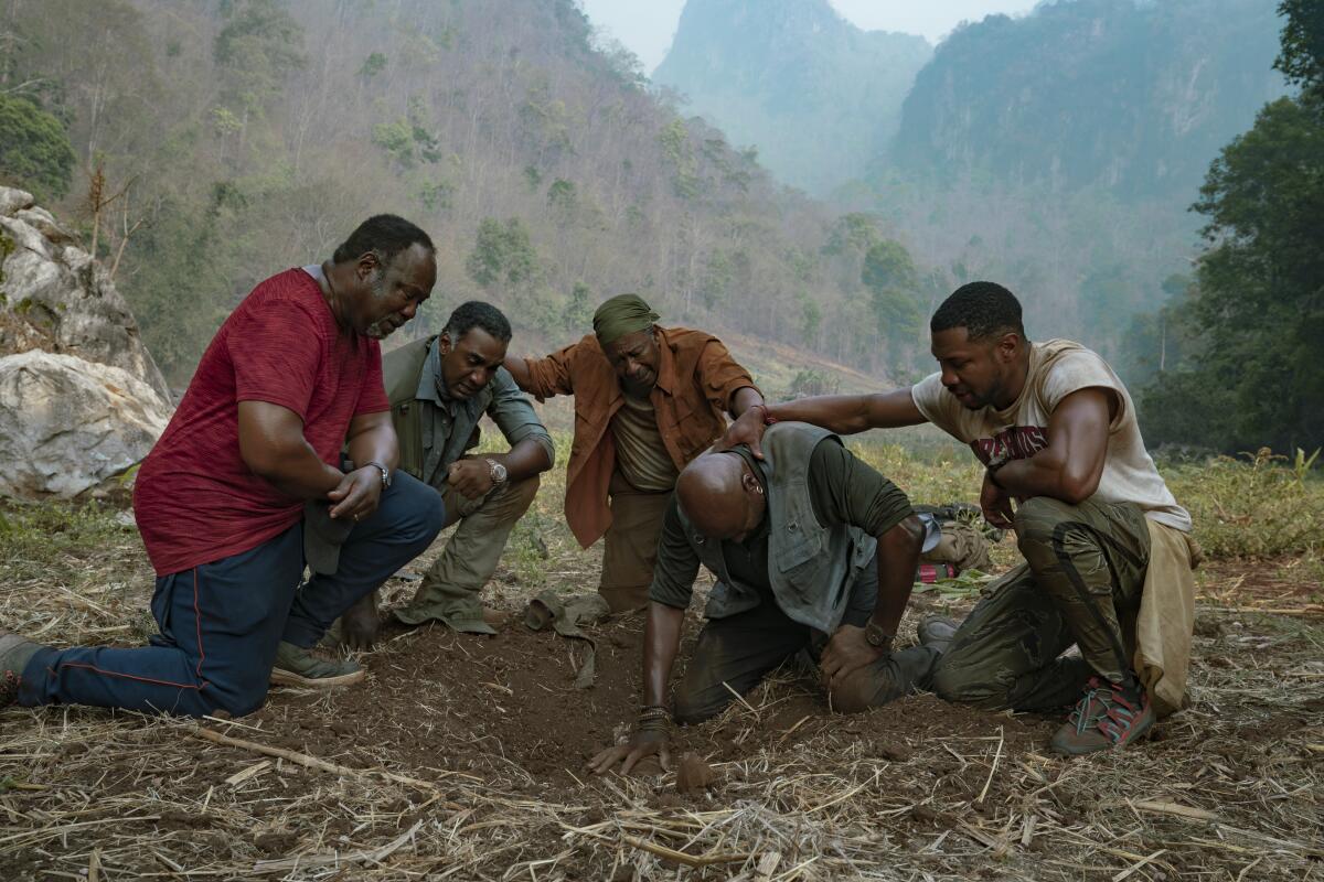 Isiah Whitlock Jr., Norm Lewis, Clarke Peters, Delroy Lindo and Jonathan Majors kneeling on the ground in "Da 5 Bloods."