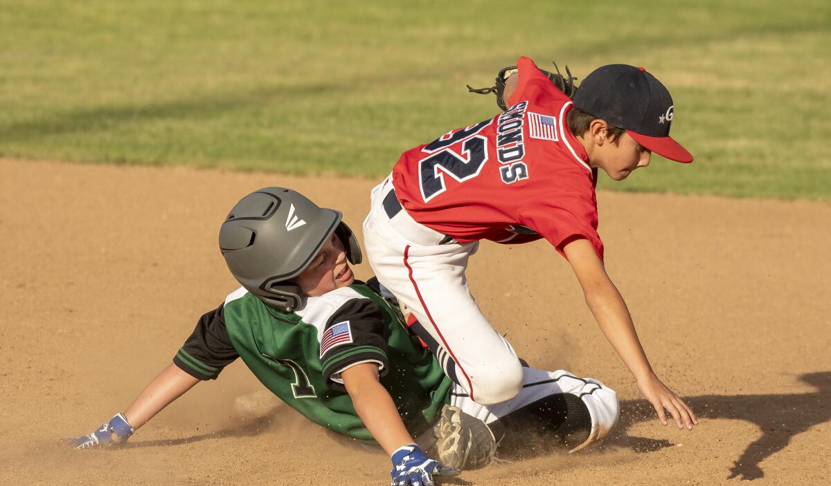Evan Simonds of Ocean View Little League tries to makes a play at second base on a sliding Luke Jacobson of Thousand Oaks Little League in the Southern California state tournament on Wednesday at Stearns Champions Park in Long Beach.