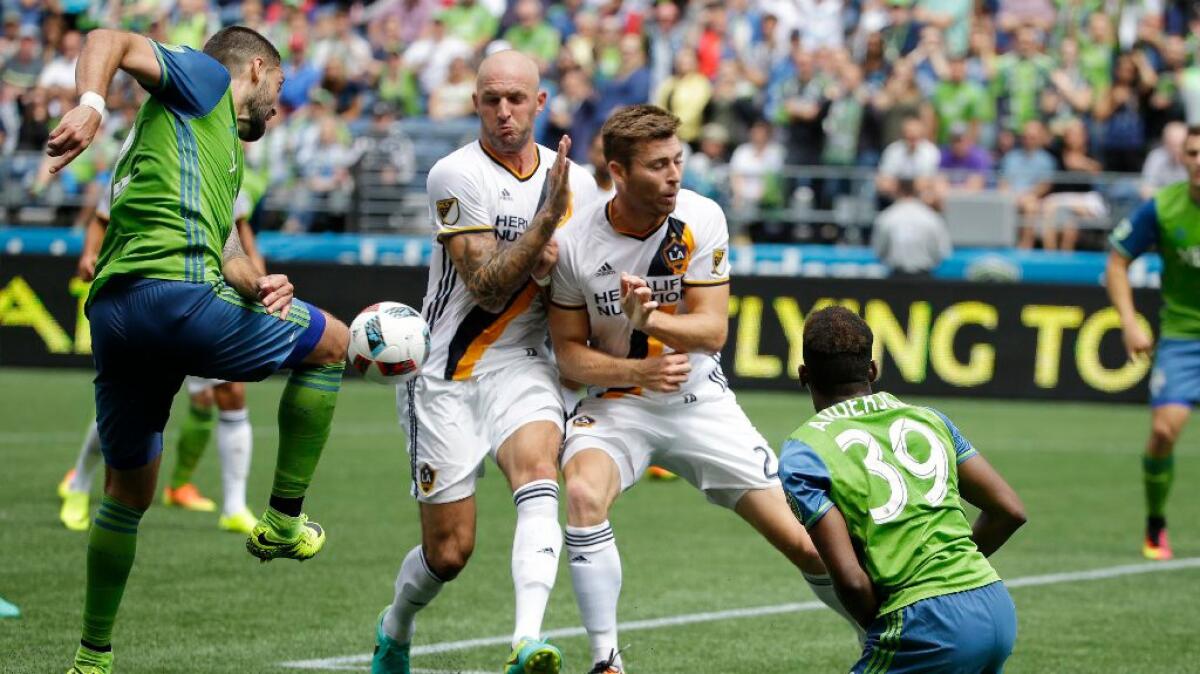 Sounders forward Clint Dempsey has a kick blocked by Jelle Van Damme of the Galaxy during a match on July 9.
