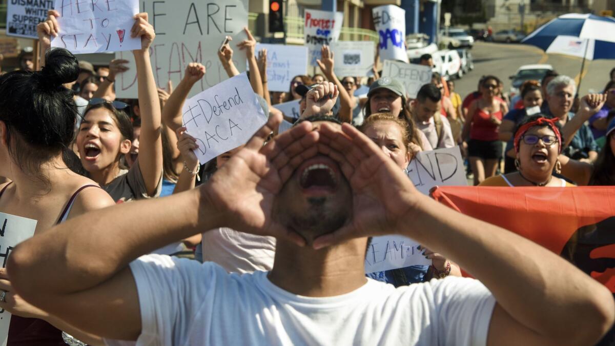 Jorge Herrera, a recipient of the Deferred Action for Childhood Arrivals program, chant slogans during a Labor Day protest.