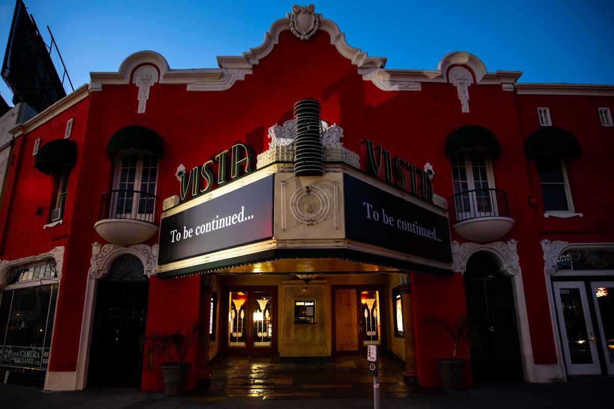 The front of a red old-school moviehouse at dusk 