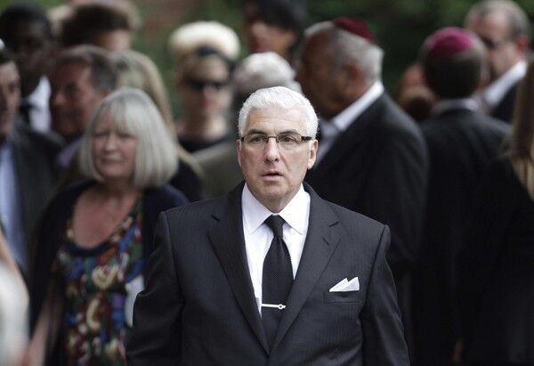 Amy's father, Mitch Winehouse, walks among fellow mourners at the funeral.