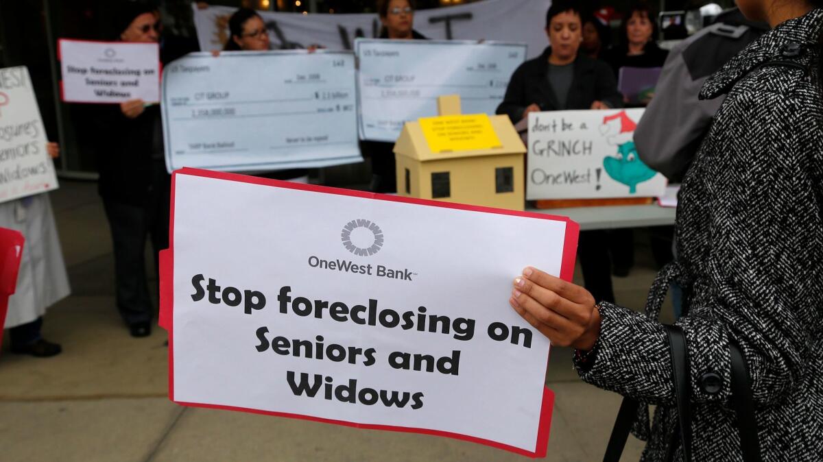 Protesters gather outside a OneWest Bank in Pasadena in 2014. A group led by Steve Mnuchin netted billions from the sale of the bank last year.