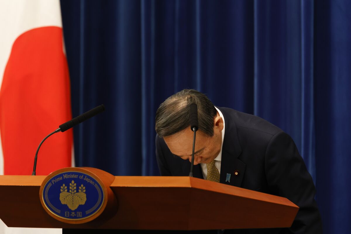 Japan's Prime Minister Yoshihide Suga bows during a press conference at the prime minister's official residence Wednesday, Jan. 13, 2021, Tokyo, Japan. Suga announced that Japan has expanded a coronavirus state of emergency for seven more prefectures Wednesday, affecting more than half the population amid a surge in infections across the country. (Rodrigo Reyes Marin/Pool Photo via AP)