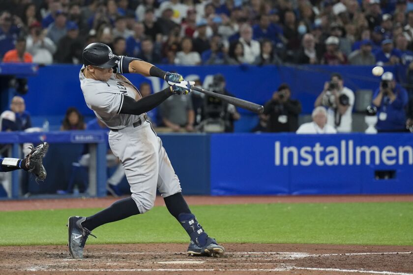 New York Yankees' Aaron Judge hits a two-run home run, his 61st homer of the season, during the seventh inning of the team's baseball game against the Toronto Blue Jays on Wednesday, Sept. 28, 2022, in Toronto. (Nathan Denette/The Canadian Press via AP)