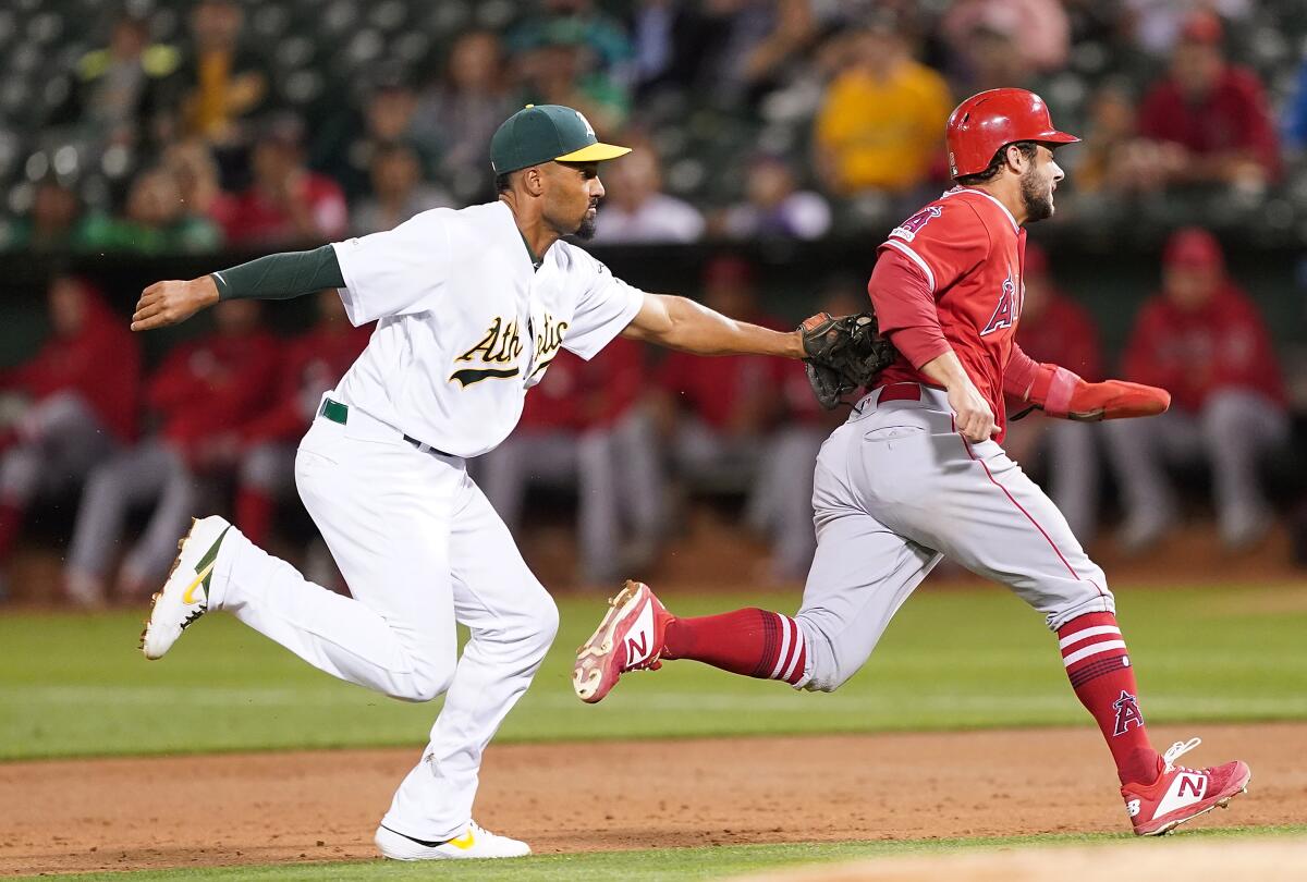 Oakland Athletics shortstop Marcus Semien tags out Angels baserunner David Fletcher during the third inning of the Angels' 7-5 loss Tuesday.