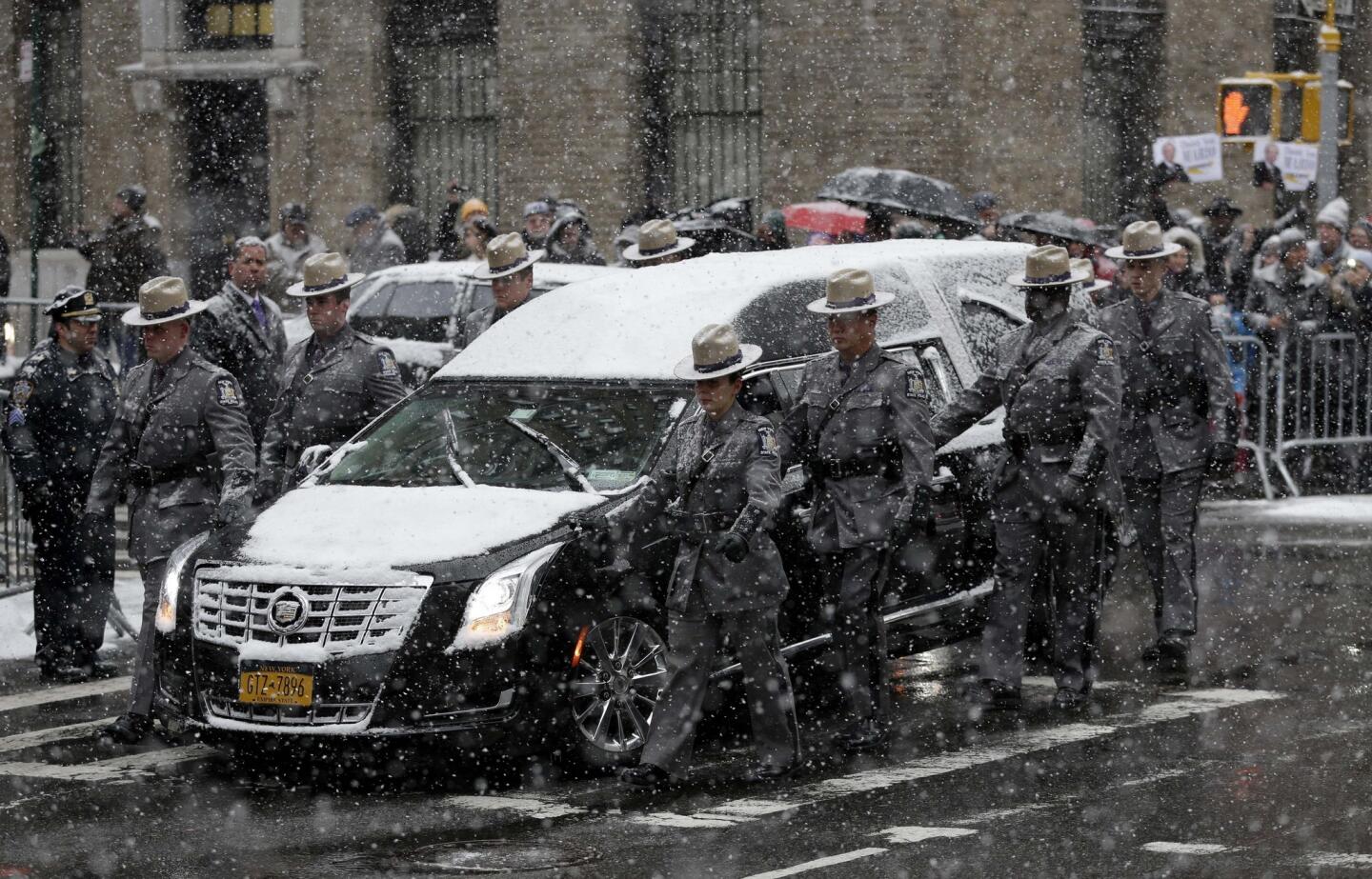 A hearse carrying the body of former New York Gov. Mario Cuomo is flanked by state troopers during his funeral at Church of St. Ignatius Loyola in New York. Cuomo, 82, died in his Manhattan home on Jan. 1, hours after his son Gov. Andrew Cuomo was inaugurated for a second term.