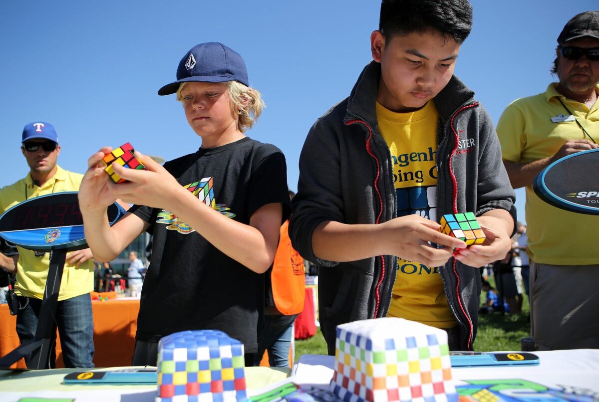 Alex Branch and Josh Pasco concentrate as they take part in a Rubik's Cube competition at Super STEM Saturday at California State University San Marcos.