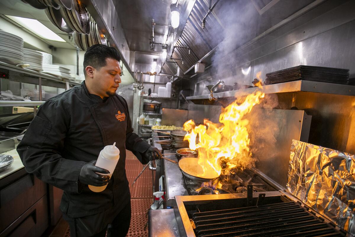 Freddy Mendez, the general manager of Cambalache Grill Argentine and Italian Cuisine, prepares a dish on Tuesday.